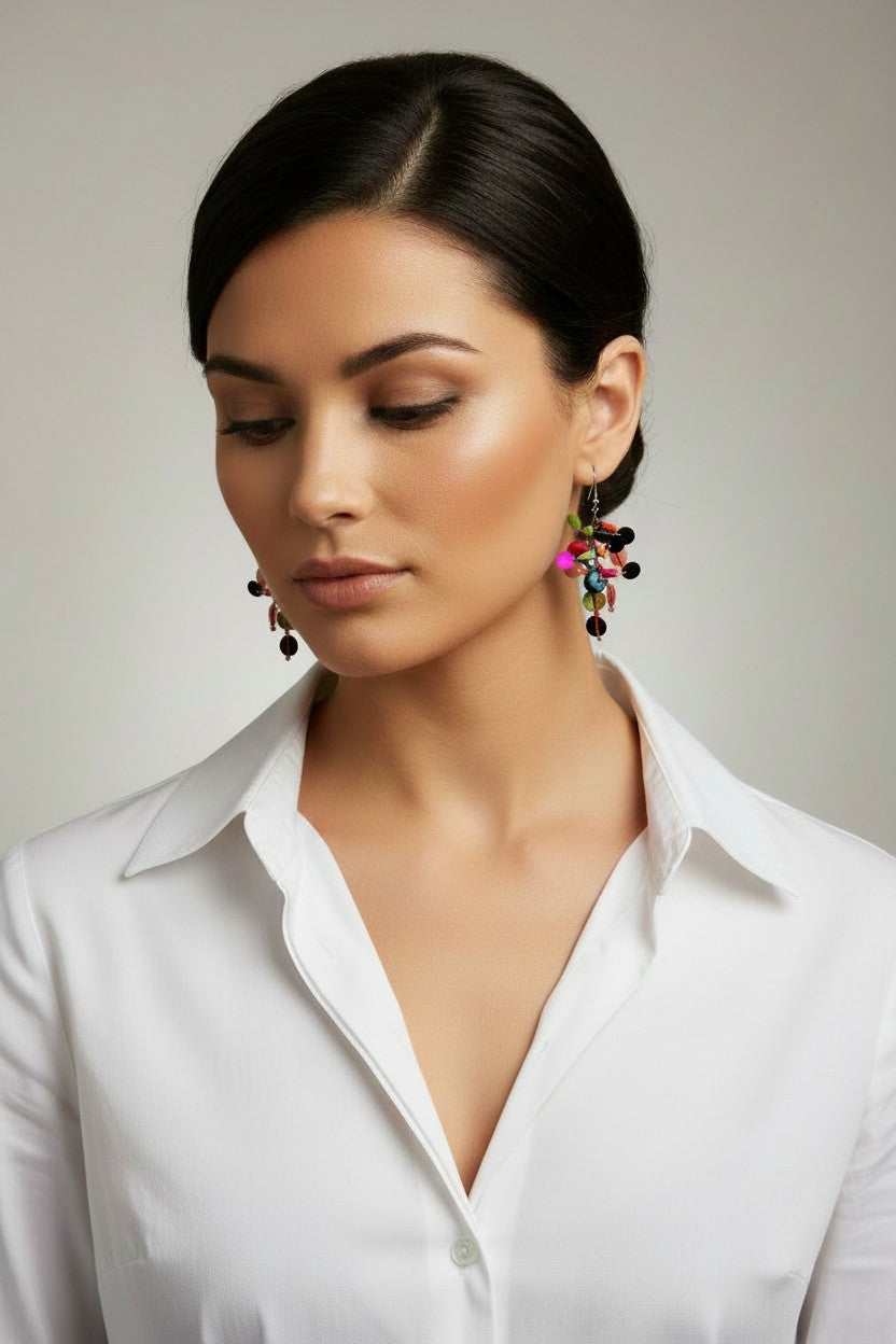  woman slightly turning her head wearing a pair of lightweight bohemian drop earrings with cascading multicolored disc charms on silver-tone fishhook backings.