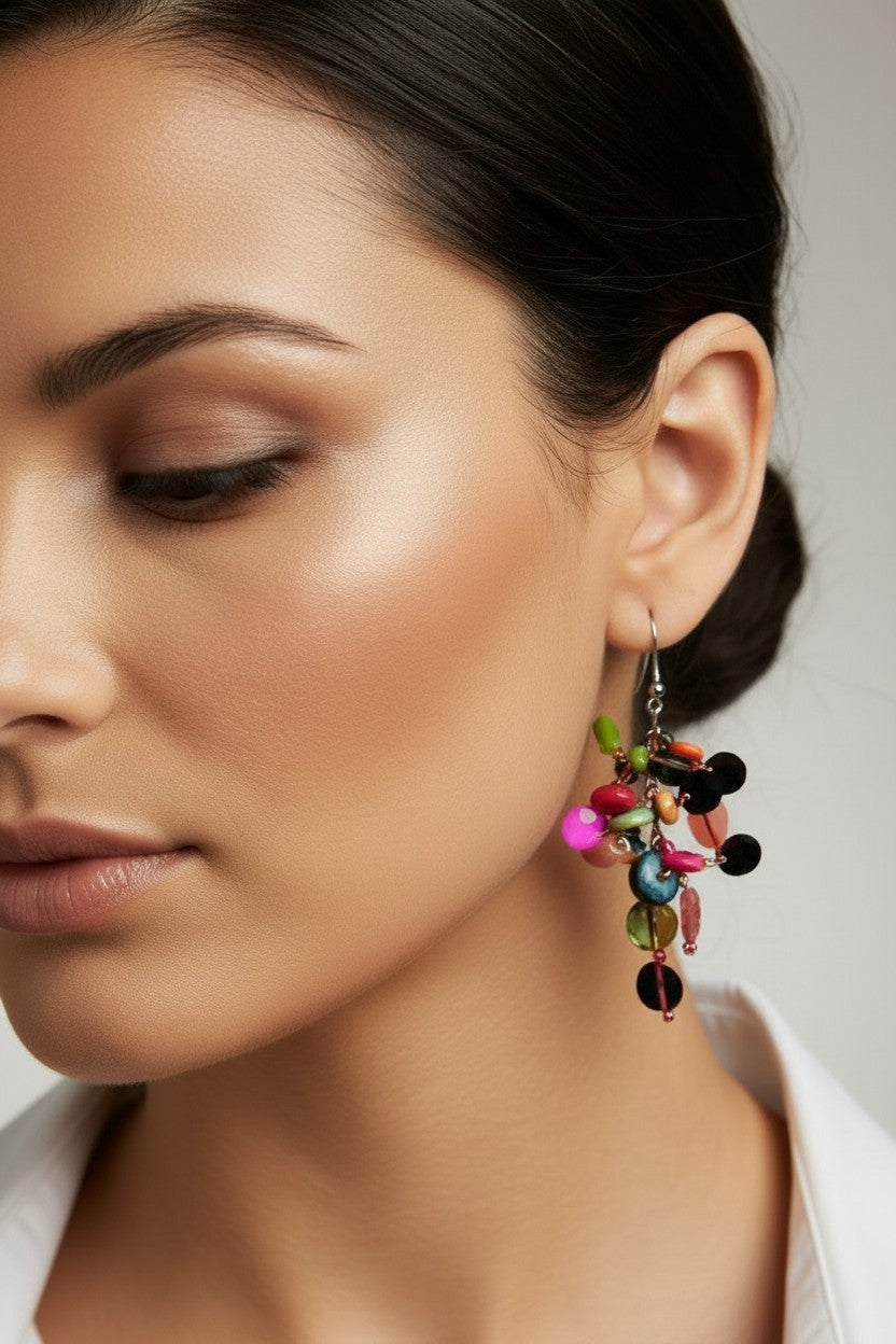 close up side view of woman wearing a pair of lightweight bohemian drop earrings with cascading multicolored disc charms on silver-tone fishhook backings.