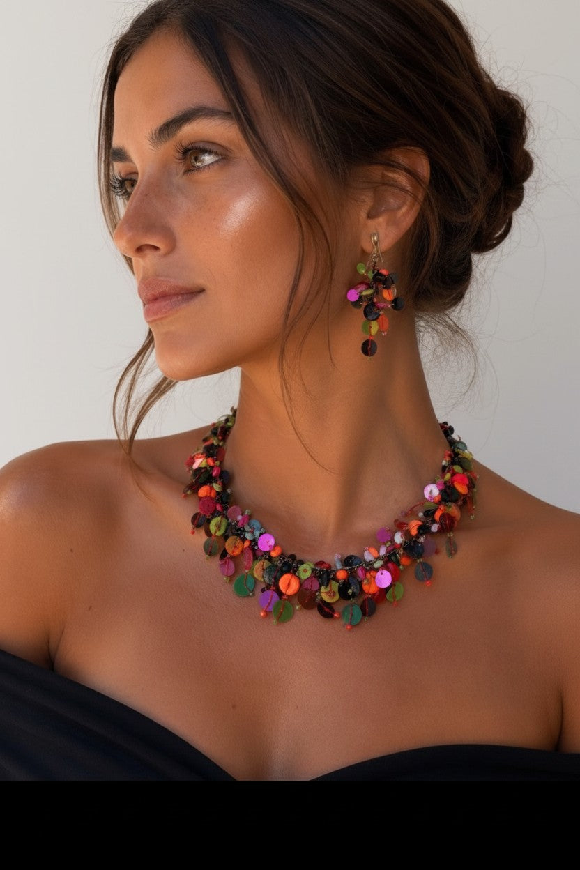Close-up of woman wearing a bohemian choker necklace showcasing a dense cluster of multicolored coin charms on a woven metallic band.