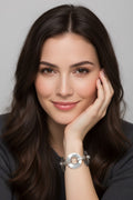  A close-up view of a model resting her chin on her hand, showcasing a silver-plated geometric disc link bracelet on her wrist.